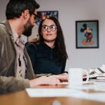 A businessman and woman, who William Smith of Double Iron Consulting can help, sit at a table